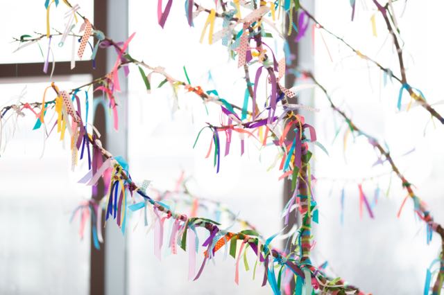 A tree branch is adorned with colourful ribbons representing each birth at the TBC.