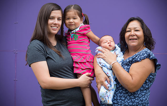 Photo of a family with their aboriginal midwife holding their newborn.