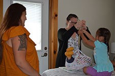 Photo of midwife weighing baby with family at Six Nations birth centre.