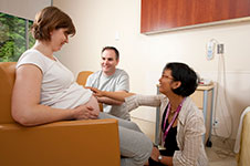 Photo of a couple with their midwife in hospital.