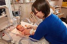 Photo of a midwife assessing a newborn in a hospital.