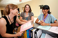 Photo of a midwife talking with other hospital staff.