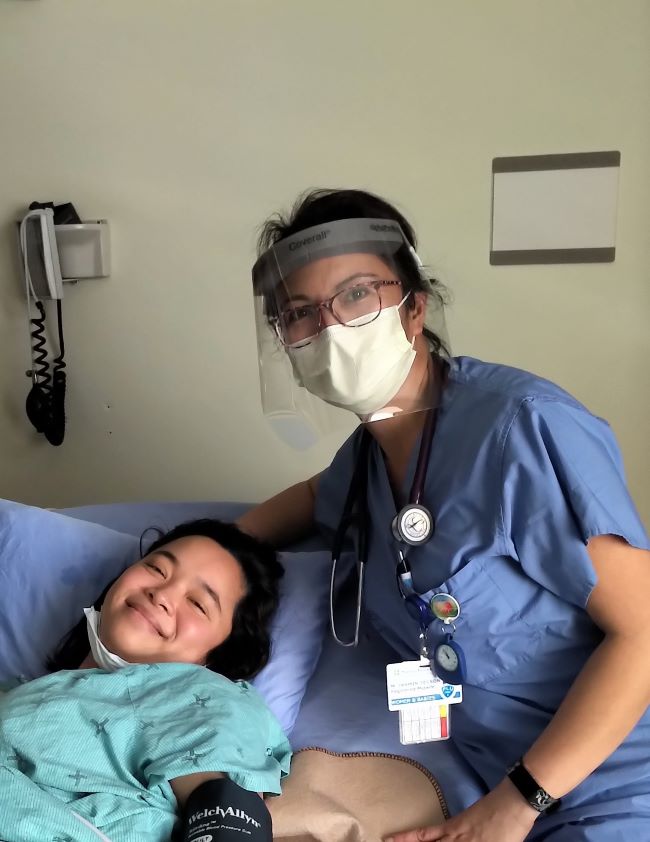 Midwife and AOM President Jasmin Tecson stands at the bedside of client Chaya Go at hospital birth in Toronto, ON.